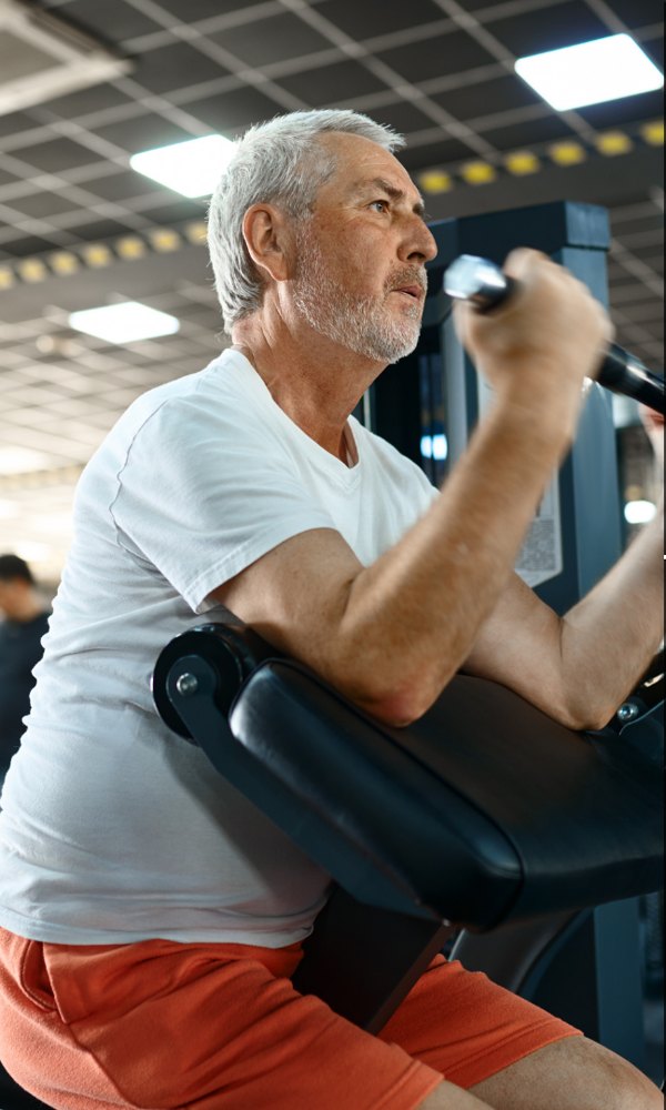 A 360 Fitness client over 50 training on a machine with his coach